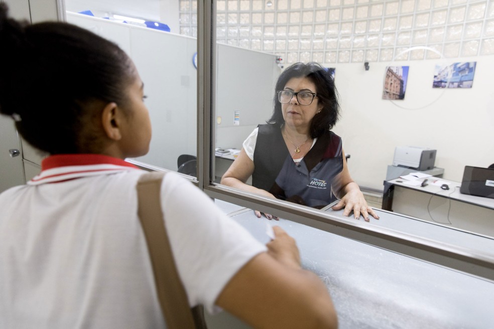 Laurinda Mendes trabalha no departamento de finanças atendendo estudantes, fazendo matrículas e recebendo pagamentos — Foto: Marcelo Brandt/G1