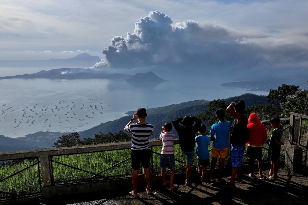 Moradores observam de longe a enorme nuvem de cinzas emitida pelo vulcão Taal em Tagaytay City, na província de Cavite, nas Filipinas — Foto: Eloisa Lopez/Reuters
