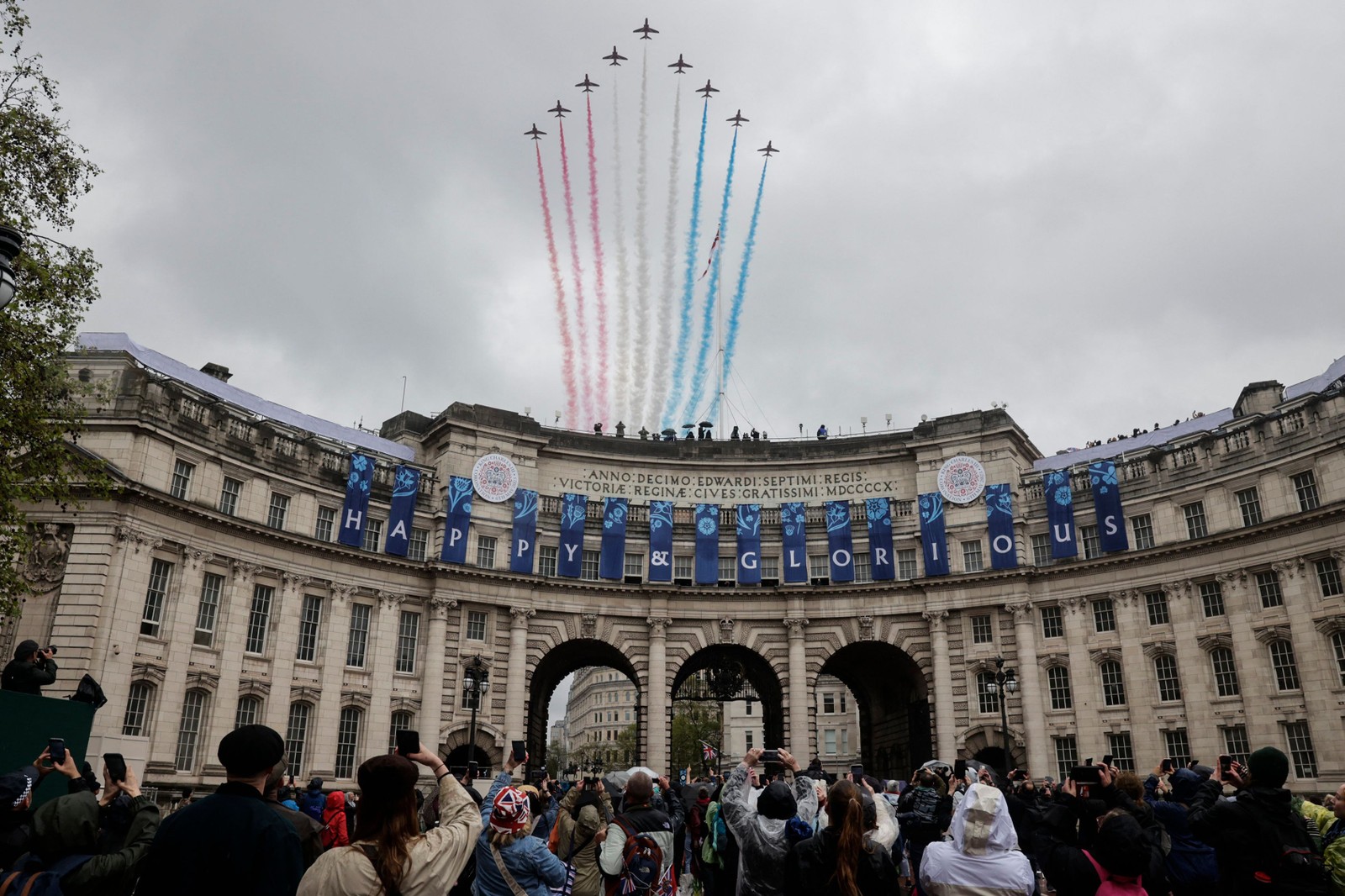 A equipe acrobática da Força Aérea Real Britânica, os "Red Arrows", realizam um sobrevoo sobre o Arco do Almirantado, no centro de Londres, após as coroações do rei Charles III e da rainha Camilla — Foto: CARLOS JASSO / AFP