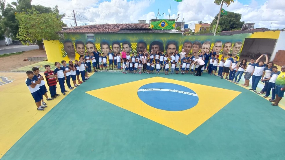 Estudantes visitam rua pintada com jogadores do Brasil. Uma das paredes homenageia craques que conquistaram títulos pela seleção. — Foto: Cedida