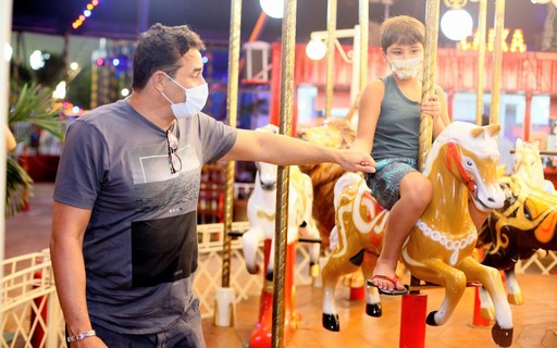 Luciano Szafir brinca com filho em carrossel de parque
