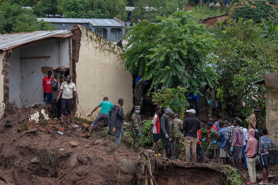 Soldados da Força de Defesa do Malauí assistem a população atingida pelo ciclone Freddy no assentamento de Manje, em Blantyre