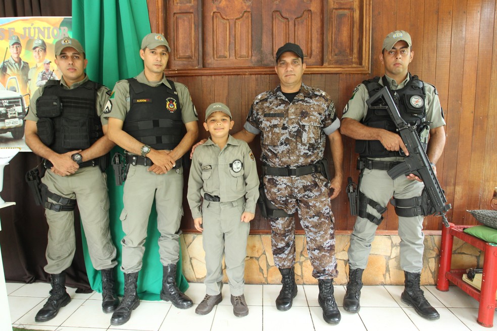 Menino posou ao lado de policiais e disse que quer ser PM para ajudar população (Foto: Diego Gurgel/Secom Acre)
