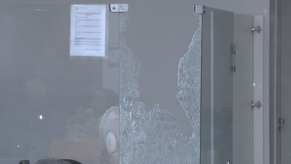 Irritada com atendimento, mulher joga pedra e quebra vidro da recepção do Hmib, no DF — Foto: Reprodução/TV Globo