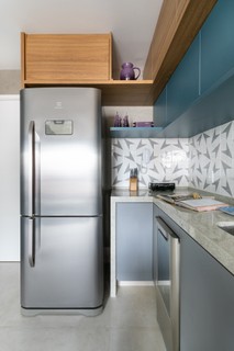 Na cozinha, os nichos de marcenaria desenhados pelo escritório Concretize e executado por Marcenaria RC Moveis são replicados no restante do apartamento