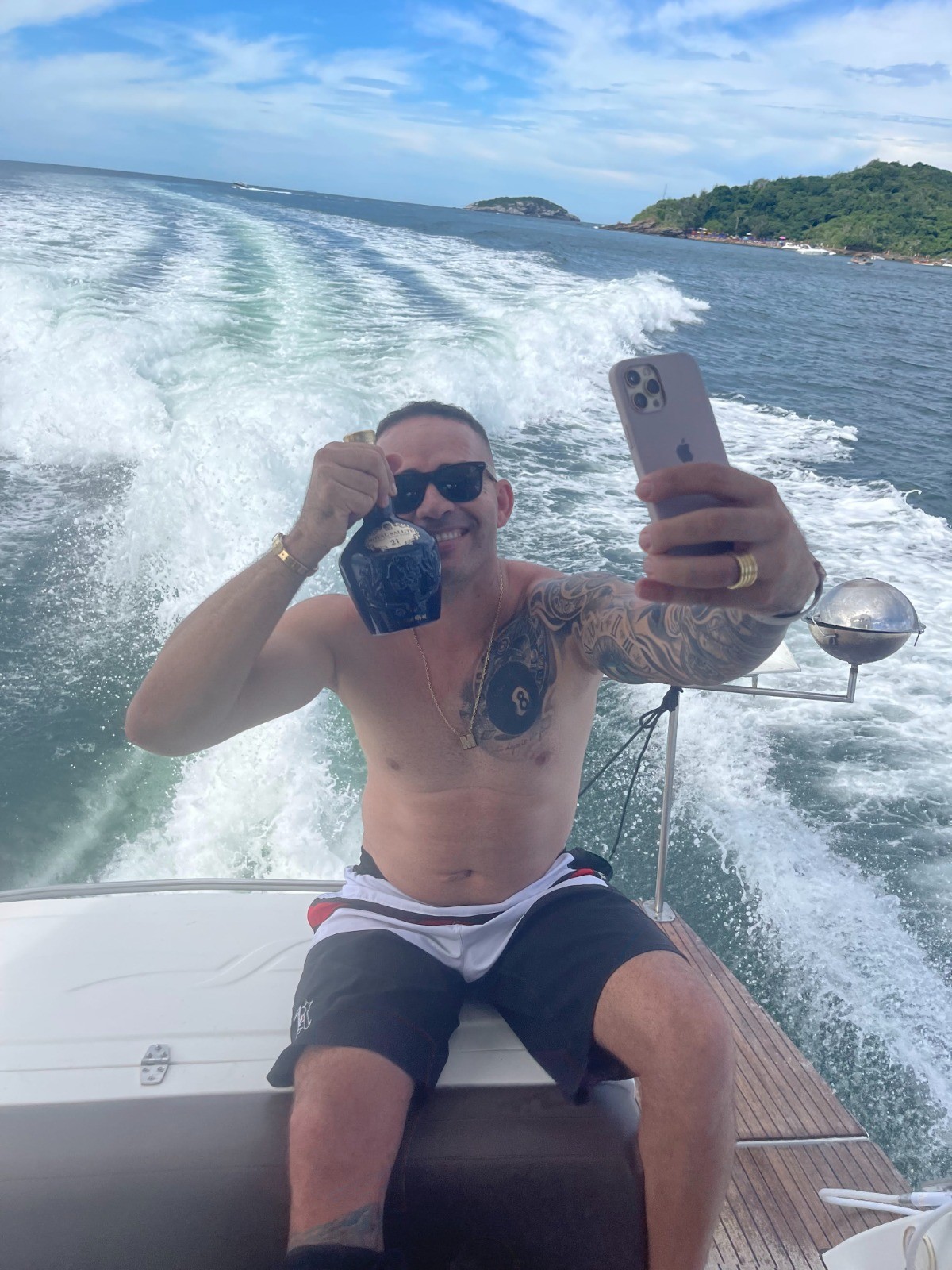 Marcelo Morais dos Santos faz selfie segurando uma garrafa de bebida na lancha / Foto: Reprodução