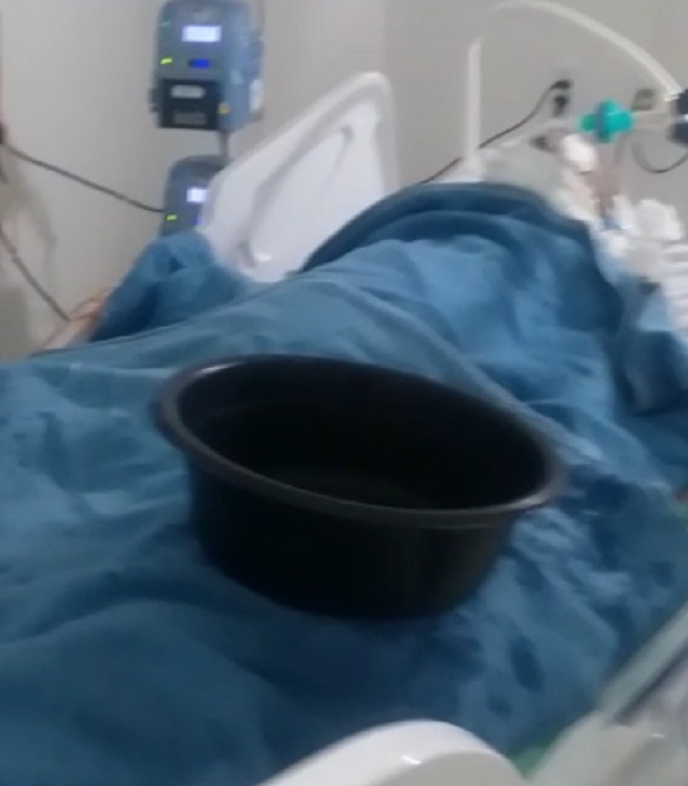 Bacia sobre leito de paciente no Hospital Regional Tarcísio Maia, em Mossoró — Foto: Reprodução