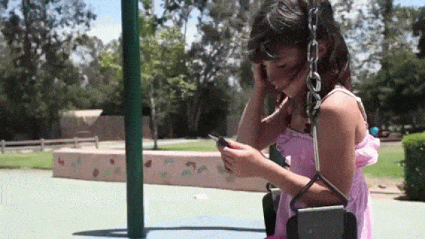 Garota observa smartphone em cena do vídeo 'I Forgot My Phone', da humorista Charlene deGuzman. (Foto: Reprodução/YouTube)
