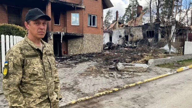 Veículos blindados russos deixaram às pressas sua base na rua Vygovskogo, em Irpin. O morador local Oleksandr Bielokon mostra os danos deixados para trás (Foto: BBC)