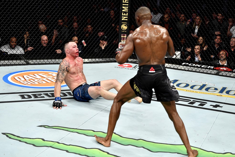 Kamaru Usman (dir.) leva Colby Covington a knockdown com um golpe de direita no quinto round — Foto: Jeff Bottari/Getty Images