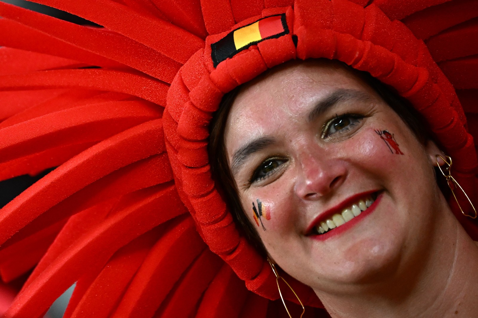 Torcedora da Bélgica sorri antes da partida contra o Canadá, pelo grupo F — Foto: JACK GUEZ/AFP