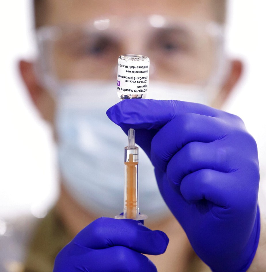 Um médico militar prepara a vacina contra coronavírus Oxford/AstraZeneca antes de ser administrada a pacientes no centro de vacinação em massa de Elland Road, em Leeds, Inglaterra
