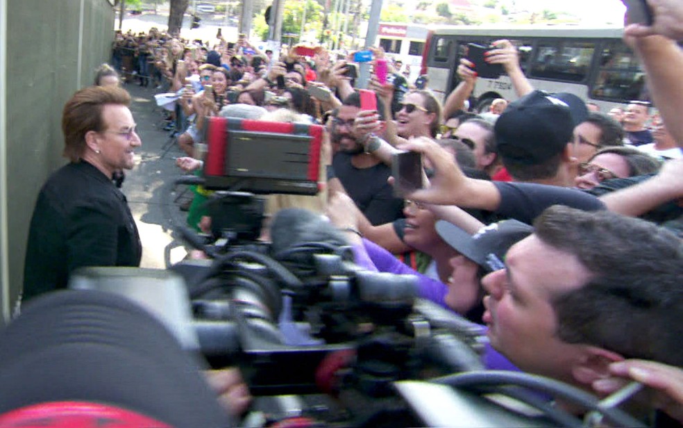 O cantor Bono Vox chega próximo às pessoas na fila do Morumbi para dar autógrafos (Foto: TV Globo/Reprodução)
