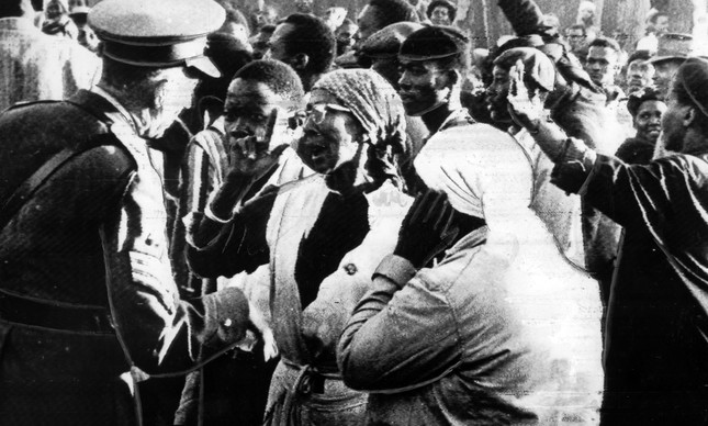 Mulheres e um policial dialogam durante manifestação em Sharpeville