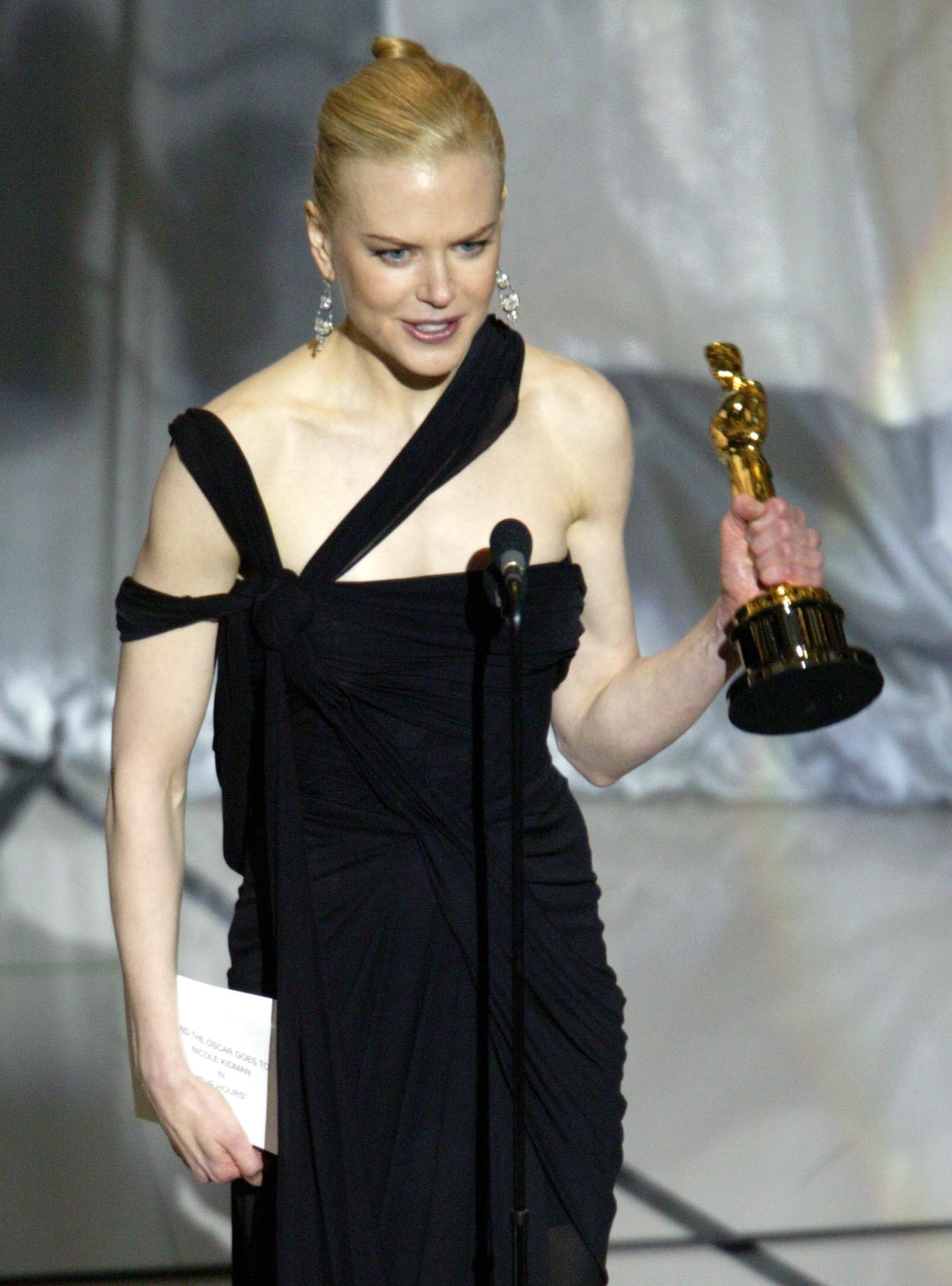 Quando Nicole Kidman recebeu seu Oscar de Melhor Atriz, em 2003, Jean Paul Gaultier a vestiu com um vestido assimétrico azul meia-noite. A roupa que custou cerca de US$ 22 mil há 20 anos, vale hoje US$ 25 mil, segundo a Bazaar — Foto: AFP