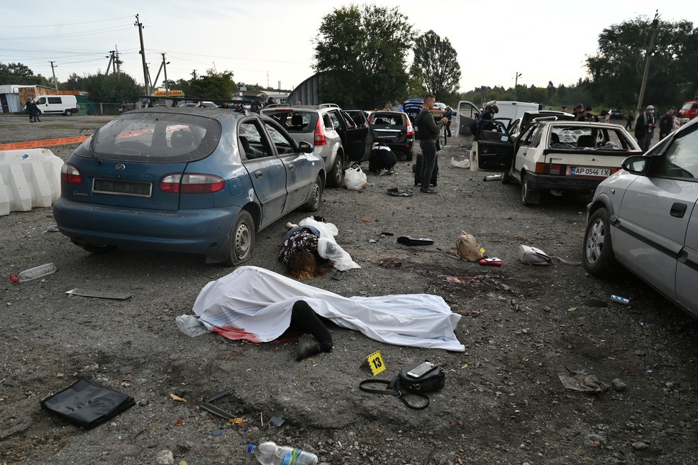 Corpos pelo chão em Zaporizhzhia, na Ucrânia, após comboio de carros ser atingido por ataque de mísseis que, segundo a Ucrânia, partiu de forças russas, em 30 de setembro de 2022. — Foto: Reuters