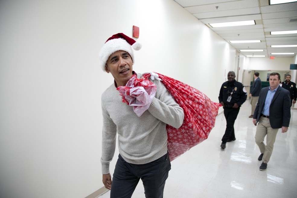 Barack Obama chega ao Hospital Infantil Nacional, em Washington, com presentes de Natal para distribuir aos pacientes — Foto: Chuck Kennedy/ AFP