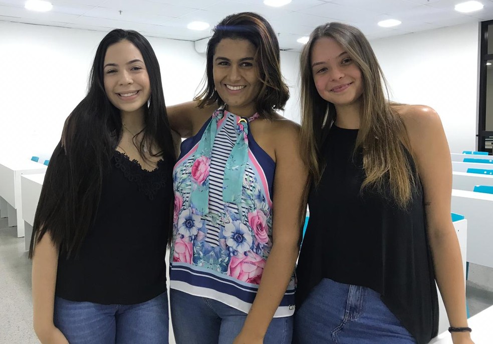 A professora Sharlene Leite ao lado das estudantes do DF nota mil na redação do Enem 2018: Iohana Freitas e Natália Patrício — Foto: Letícia Carvalho/G1