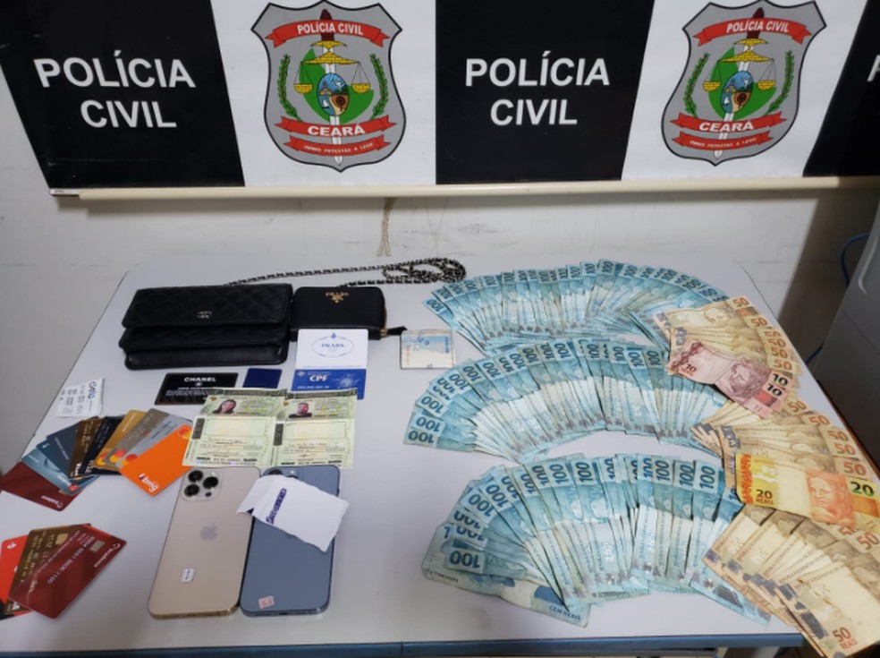 Foram encontrados documentos falsos, diversos cartões bancários e R$ 9 mil em dinheiro.  — Foto: Polícia Civil