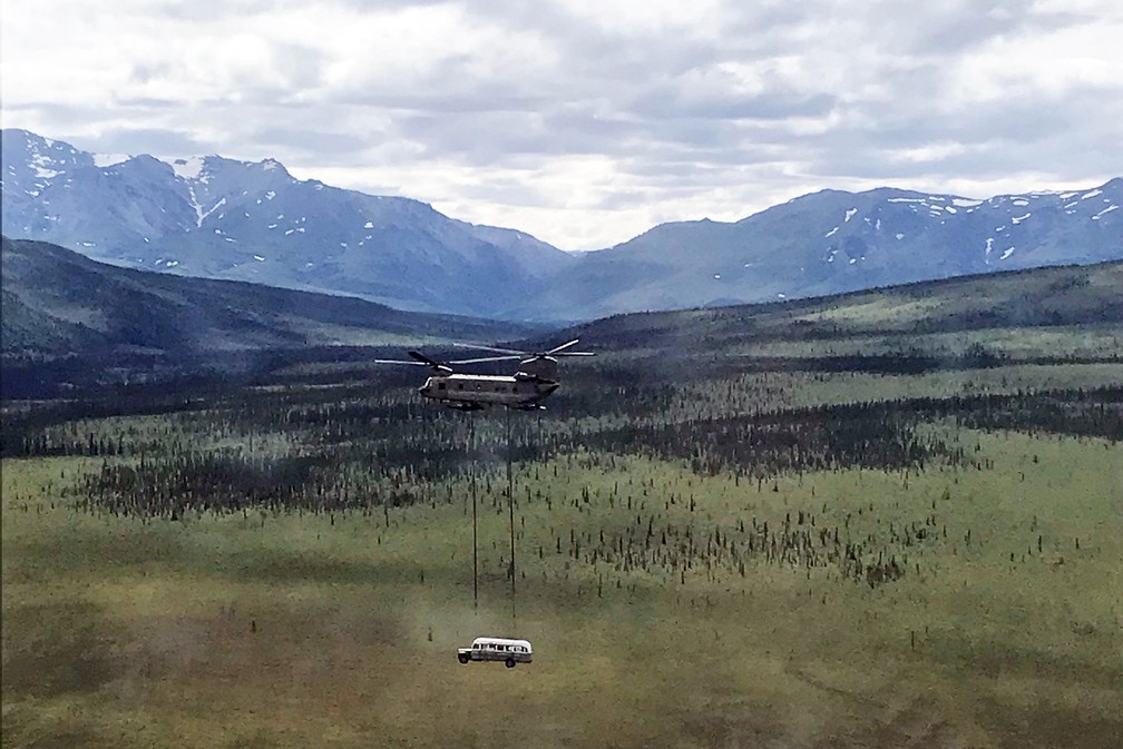 Helicóptero carrega ônibus que ficou famoso no livro e no filme 'Na natureza selvagem' sobre o Parque Nacional de Denali, no Alasca — Foto: Seth Lacount/Guarda Nacional do Exército do Alasca/AFP