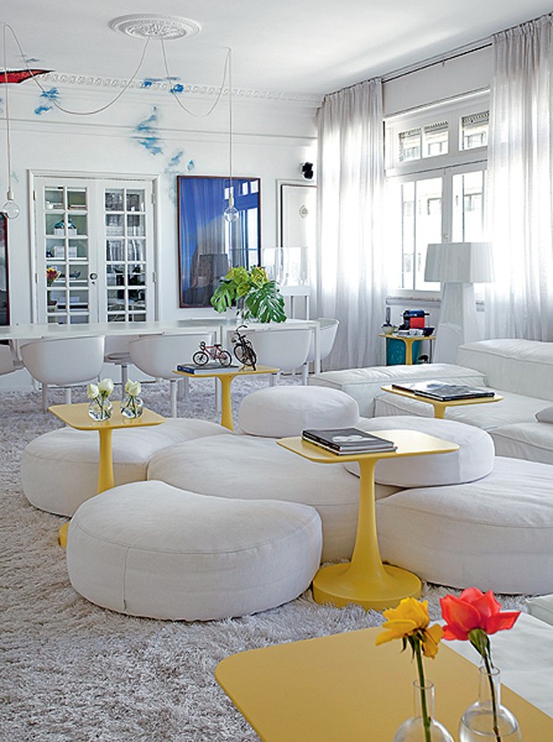 Entre o mar de brancos do apartamento do arquiteto David Bastos, destacam-se as mesas de apoio amarelas, design de Paola Navone. Todo o resto é como a neve: módulos, tapete, paredes, cortina, mesa de jantar e cadeiras (Foto: Tuca Reinés e Denilson Machado/MCA Estúdio)