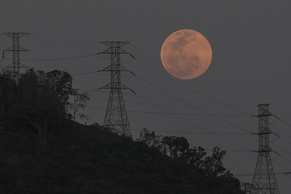 Venezuela: a lua cheia nasce atrás das torres de alta tensão em Caracas — Foto: Matias Delacroix/AP