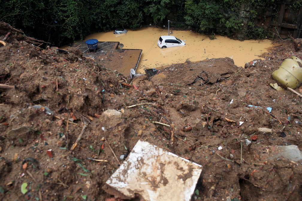 Um carro submerso é visto após deslizamento no Morro da Oficina, em Petrópolis (RJ), nesta quarta (16) — Foto: Ricardo Moraes/Reuters