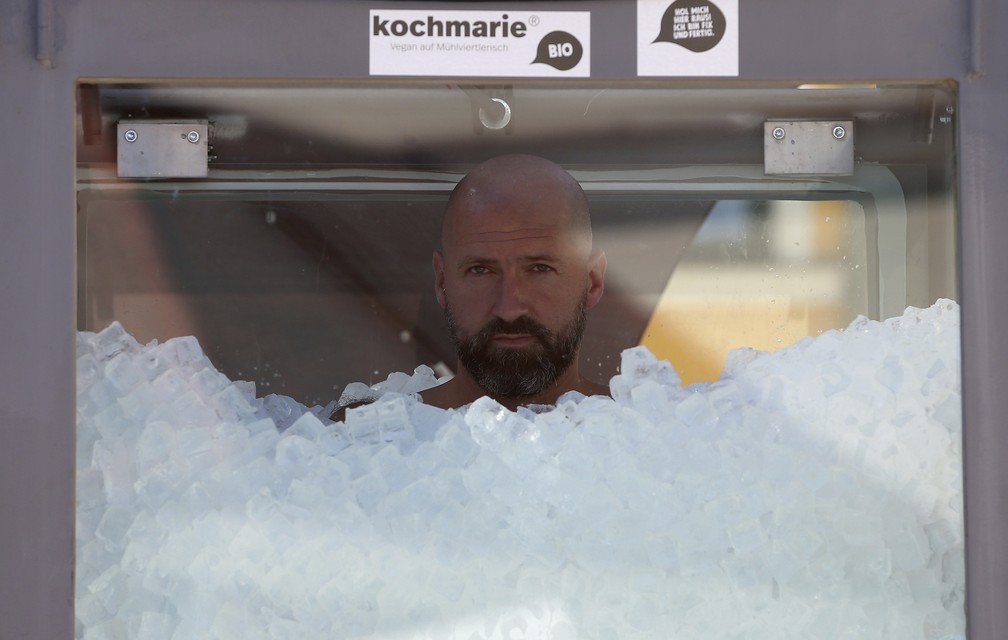 O nadador austríaco Josef Koeberl é visto dentro de uma cabine de vidro cheia de gelo tentando quebrar o recorde mundial, em Melk, Áustria  — Foto: Ronald Zak/AP