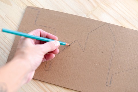 1. Desenhe a silhueta da cidade na tira de papelão, variando entre prédios e casas.