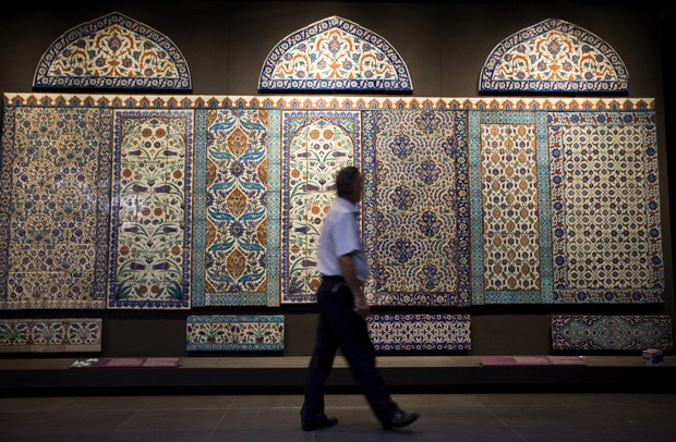 Visitante passa ao lado de mural islâmico (Foto: Ed Alcock/The New York Times)