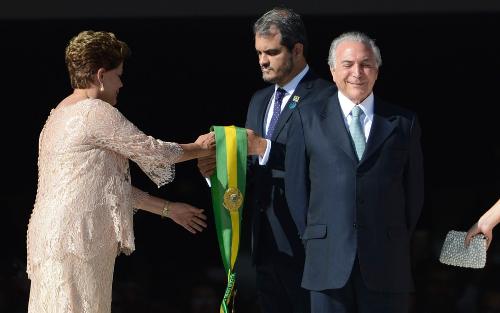 A então presidente Dilma Rousseff recebe a faixa de presidente ao lado do vice Michel Temer na cerimônia de posse em 2015 (Foto: Marcelo Camargo/Agência Brasil)