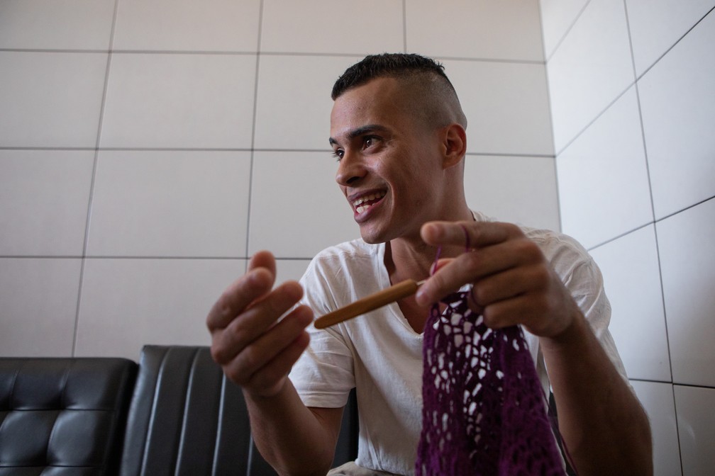 Felipe Santos da Silva, de 27 anos, conversa com a reportagem, sem parar seu crochê — Foto: Marcelo/Brandt