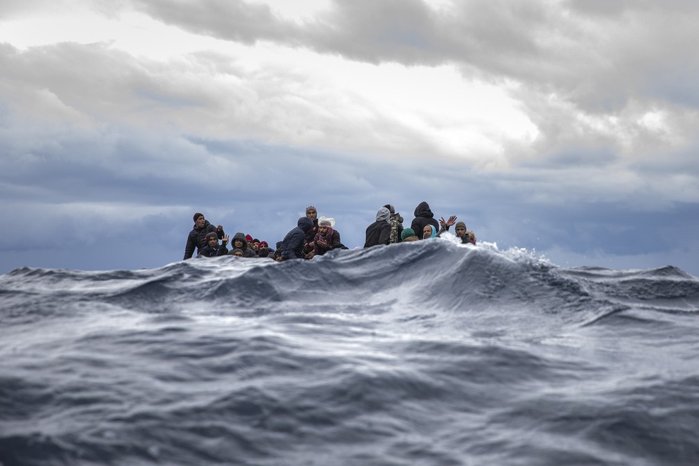 10 de Janeiro - Imigrantes do Marrocos e Bangladesh aguardam resgate em bote inflável no Mar Mediterrâneo — Foto: Santi Palacios/AP