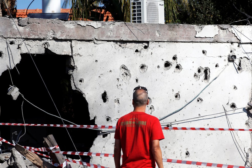 Homem olha nesta terça-feira (13) prédio danificado na cidade israelense de Ashkelon. Ele foi atingido por míssil lançado a partir da Faixa de Gaza — Foto: Ronen Zvulun/ Reuters