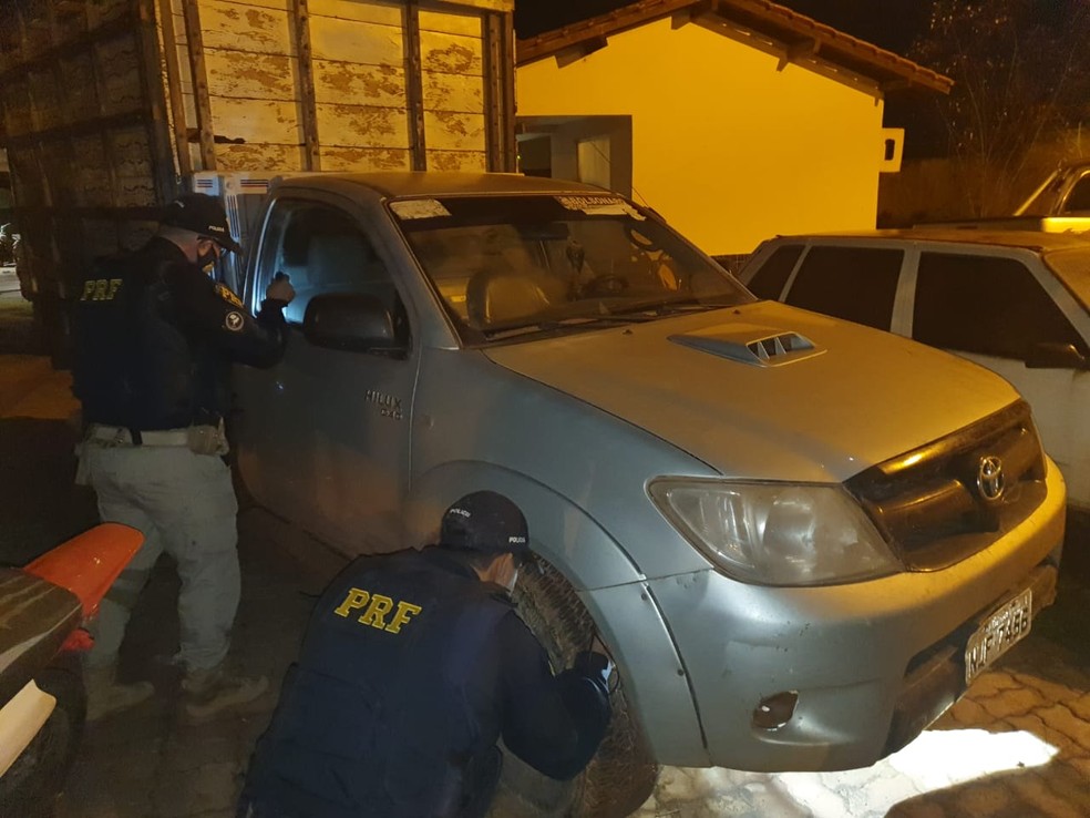 Policiais rodoviários federais verificando sinais identificadores da caminhonete — Foto: PRF/Divulgação