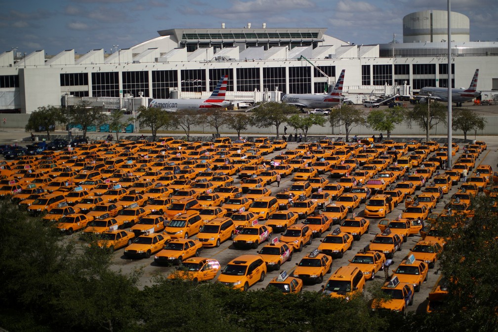 Centenas de táxis são vistos parados em um estacionamento do aeroporto Miami International afetados pela propagação da doença por coronavírus (COVID-19) em Miami, na Flórida, EUA, em 18 de março  — Foto:  Carlos Barria/Reuters