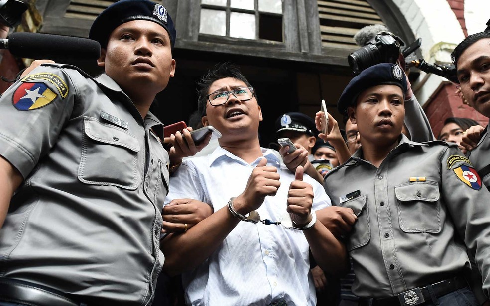 O jornalista Wa Lone é escoltado pela polícia de Mianmar depois de ter sido condenado — Foto: Ye Aung Thu / AFP