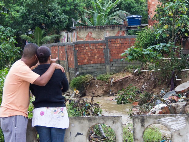 Casal de moradores da Vila Zenith em Austin, Nova Iguaçu (RJ), retorna a residência para verificar os estragos e buscar o que restou, na manhã desta quinta-feira (12). Eles tiveram que abandonar o local, que está condenado pela Defesa Civil. (Foto: Douglas Viana/Futura Press)