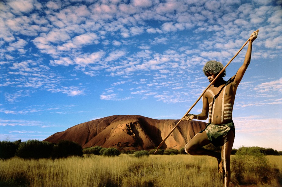 Caçador aborígine no outback australiano ao pôr do sol