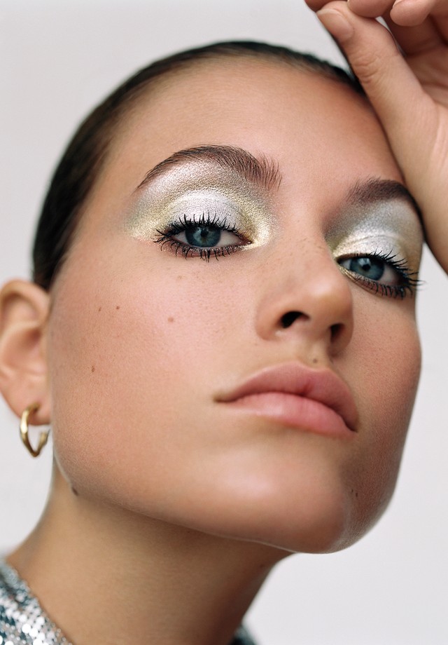 Close up of model with eyeshadow, pink lips wearing hoop earrings and metallic top (Foto: Anya Holdstock)