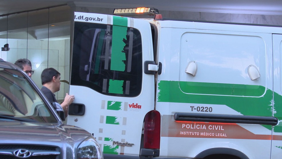 Carro do IML transporta corpo de mulher de 60 anos que caiu do terceiro andar do prédio onde morava na Asa Sul — Foto: TV Globo/Reprodução
