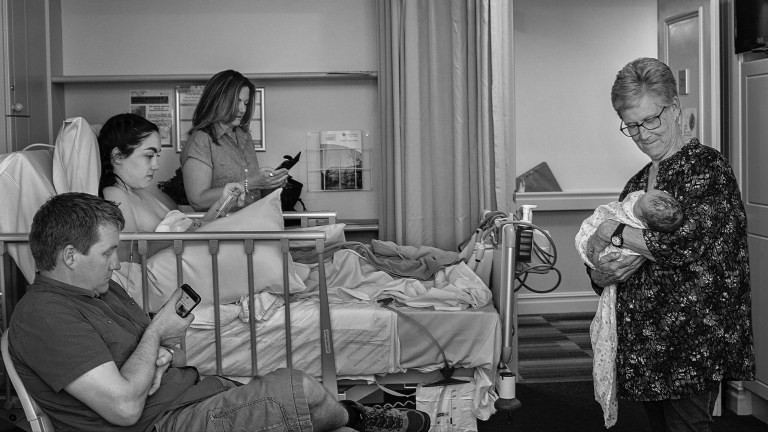 Sarah Lentz, da Austrália, capturou esta imagem em preto e branco que mostra o momento em que a família pega os celulares para avisar parentes e amigos sobre o nascimento (Foto: Sarah Lentz)