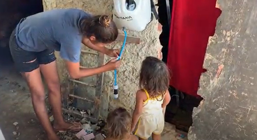 Família recebe o equipamento que filtra água em Jardim Gramacho, na Baixada Fluminense — Foto: Divulgação/Água Camelo