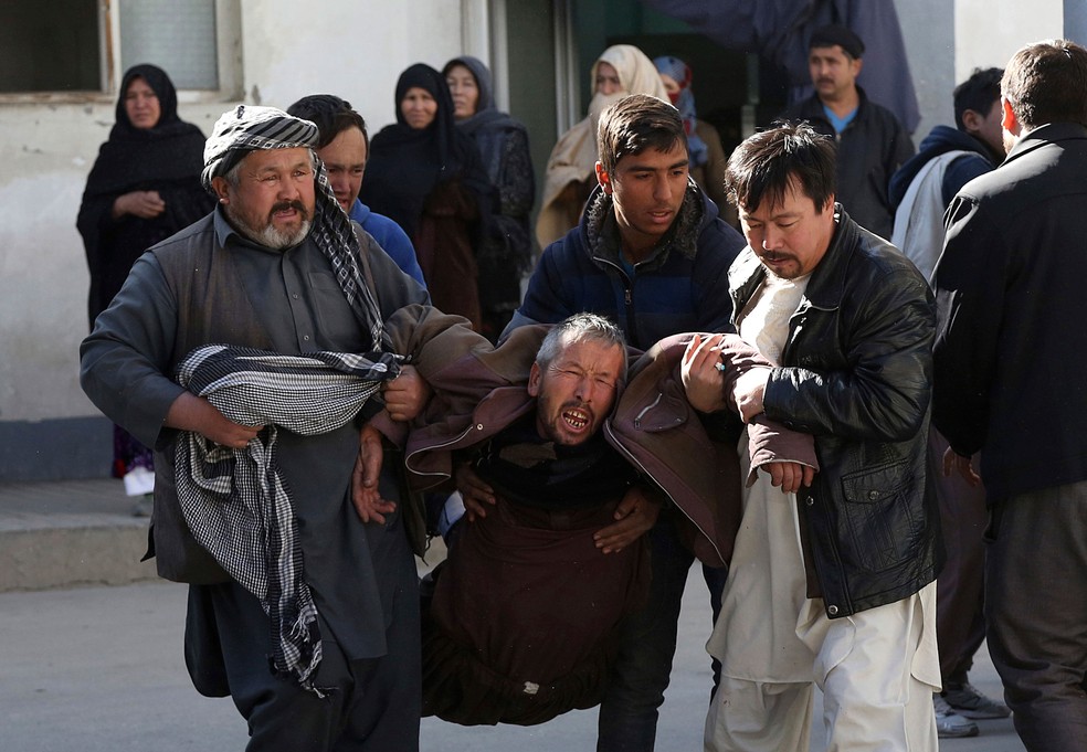 Homem é retirado de local de ataque em Cabul, no Afeganistão, nesta quinta-feira (28)  (Foto: Rahmat Gul/ AP)