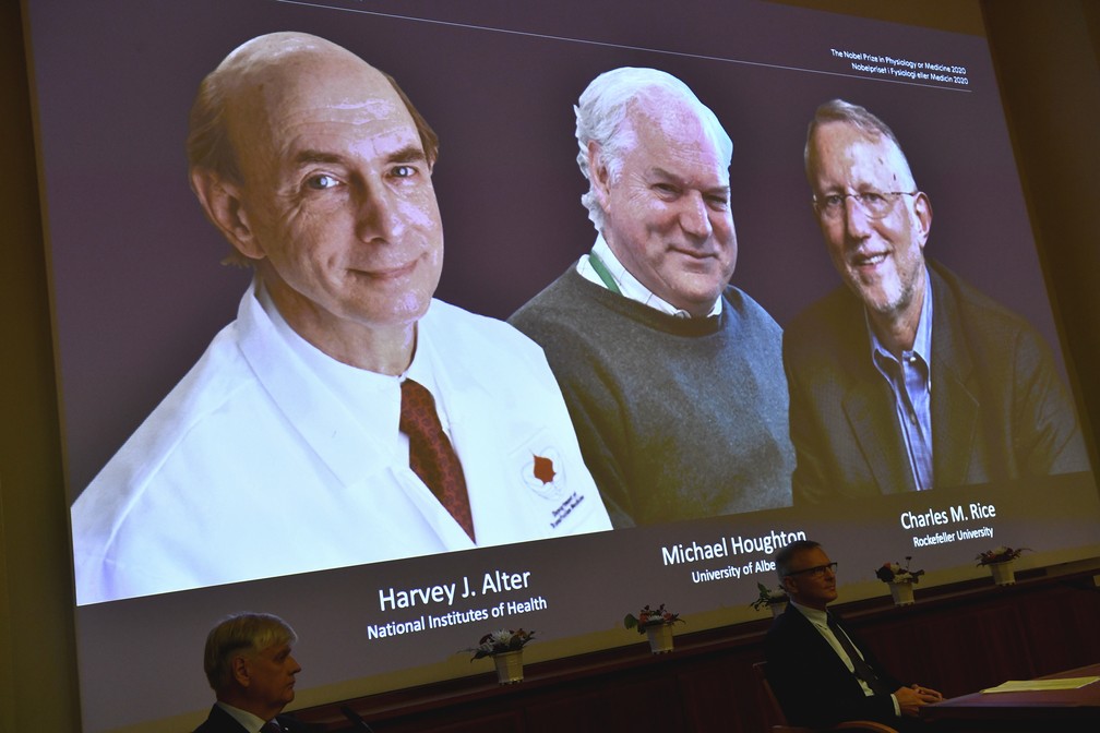Imagem projetada dos três vencedores do Nobel de Medicina: Harvey J. Alter, Michael Houghton e Charles M. Rice — Foto: Claudio Bresciani/AP