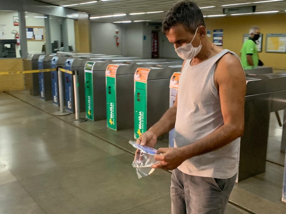 Homem recebe máscara doada pelo GDF, na estação do metrô da Praça do Relógio, em Taguatinga, no DF — Foto: G1 DF