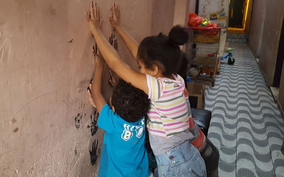 Filhos de Renata brincam no corredor de cortiço onde moram no centro de SP  (Foto: Felipe Souza/BBC Brasil)