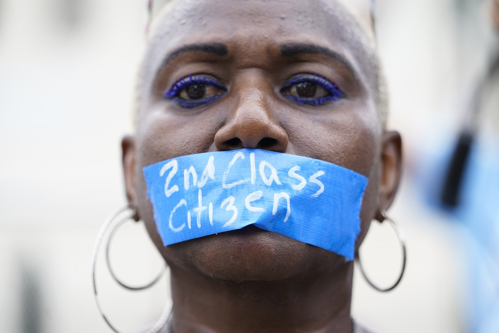 Foto mostra uma mulher negra protestando pelo direito ao aborto no dia 24 de junho, em frente à Suprema Corte dos EUA, em Washington, DC. Ela usa uma fita sobre a boca onde se lê 'cidadã de segunda classe'.  — Foto: Jacquelyn Martin/AP