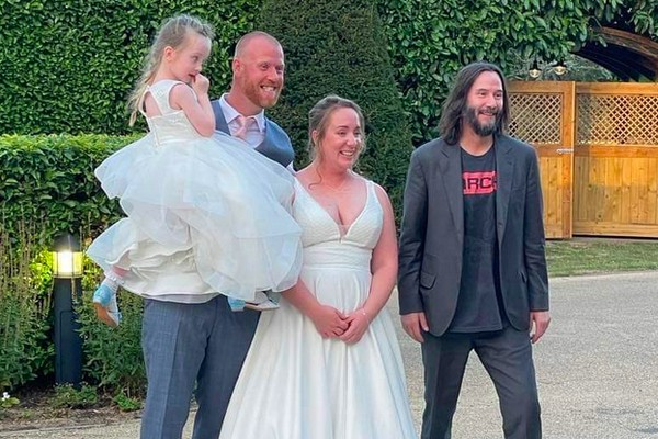 O ator Keanu Reeves com os noivos do casamento no qual ele fez um participação especial (Foto: Twitter)