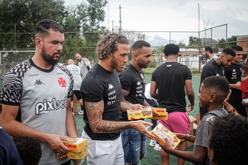 Jogadores do Vasco distribuem chocolates na Cidade de Deus — Foto: Matheus Lima / CRVG